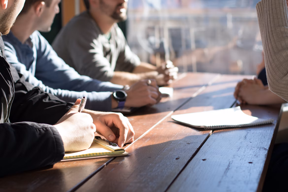 Photo of a team discussing project work around a table